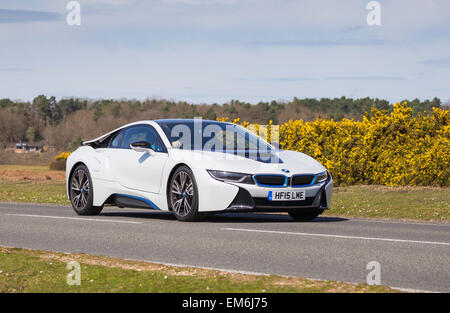 A white BMW i8 Hybrid Electric sports car drives through the New Forest National Park on a sunny day Stock Photo