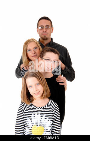 A family standing isolated on white background, dad, mother, daughter and son, standing behind each other. Stock Photo