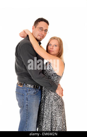 A lovely young couple standing for white background, hugging each other and facing each other, looking into the camera. Stock Photo