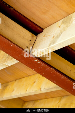 Interior of new building under construction showing steel and timber roof joists and wood used in an attic space Stock Photo