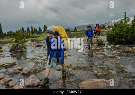 Boys cross streams during a backpack trip in the High Uintas Wilderness Area, Uintas Range, Utah Stock Photo