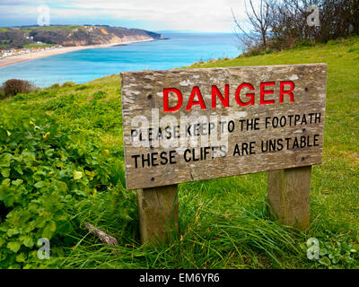 A sign reading 'Danger - please keep to the footpath these cliffs are unstable' on the cliffs between Seaton and Beer in Devon Stock Photo