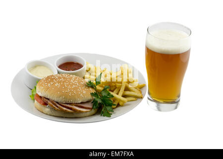 A glass of beer, a burger, french fries and sauce on a plate on an isolated background Stock Photo