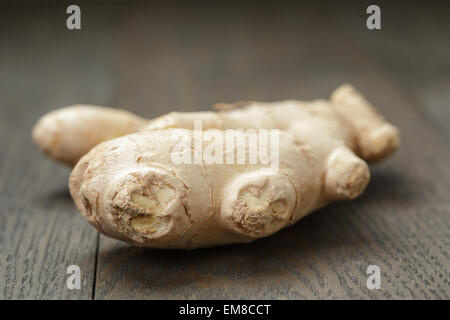 big piece of ginger root on wooden table Stock Photo