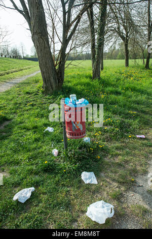 trash basket in the park and garbage on the lawn Stock Photo