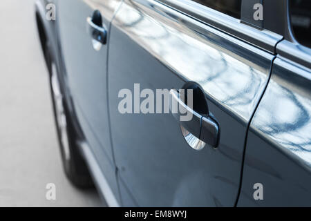 Closed rear door handle. Modern blue car closeup fragment with shallow DOF and selective focus Stock Photo