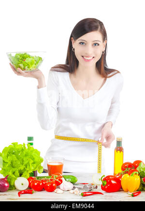 Young happy woman with salad, measuring her waistline. Healthy food ans lifestyle concept. Stock Photo
