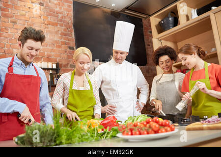 happy friends and chef cook cooking in kitchen Stock Photo