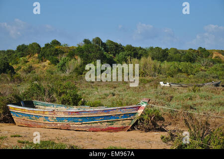 Fishing boat docked on the beach coast during low-tide Stock Photo