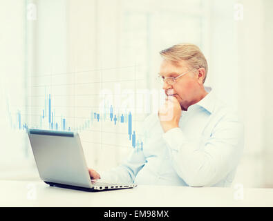 old man in eyeglasses working with laptop at home Stock Photo