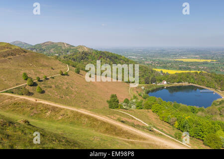 View of contour path leading to British Camp reservoir Herefordshire Beacon with Malvern HIlls and fields in background Stock Photo