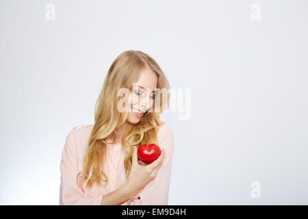 young blond woman holding a red heart. isolated on white. Stock Photo