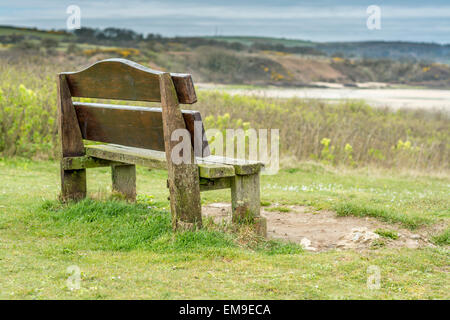 Resting place at LLigwy beach car park looking across Lligwy beach towards Dulas in the background. The bench is in sharp focus. Stock Photo