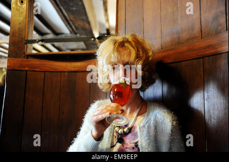 Woman drinking half pint glass of Harveys best bitter beer at the John Harvey Tavern pub in Lewes East Sussex UK Stock Photo