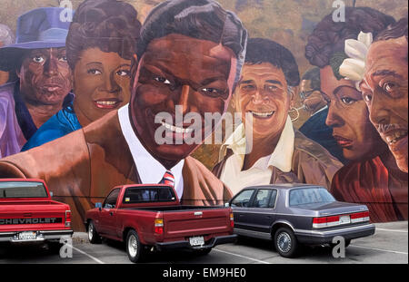 This Los Angeles landmark is a gigantic public artwork called 'Hollywood Jazz: 1945-72' that pays tribute to jazz music legends on a long wall on Vine Street in Hollywood, California, USA. The photograph was taken in 1991, one year after the massive mural was painted by Richard Wyatt Jr. He created 11 portraits, including the seven shown here (left to right):  Miles Davis, Ella Fitzgerald, Nat King Cole, Shelly Manne, Dizzy Gillespie (with horn), Billie Holiday, and Duke Ellington. When the paint began to fade and chip over the years, the artist reproduced his work on ceramic tiles in 2013. Stock Photo