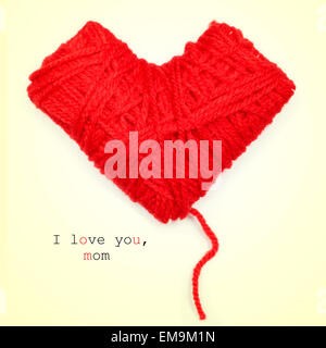 closeup of a heart-shaped coil of red yarn and the text I love you, mom, on a beige background Stock Photo