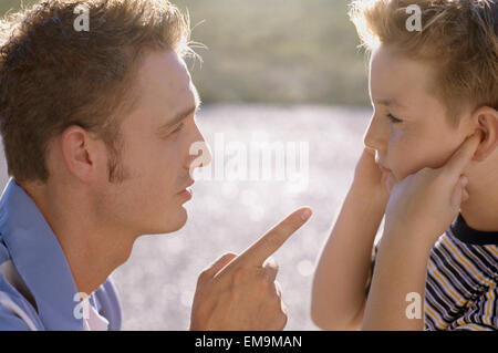 Profile portrait of father lecturing a son who is not listening Stock Photo