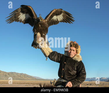 Man and bird posing, Kazakh eagle hunter and his golden eagle, Western Mongolia Stock Photo