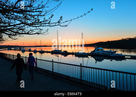 Londonderry, Northern Ireland. 18th April, 2015. UK Weather: Two women walk along the Foyle Marina at sunrise in Londonderry (Derry). Temperatures are set to remain in double figures today in Northern Ireland. . Credit:  George Sweeney/Alamy Live News Stock Photo