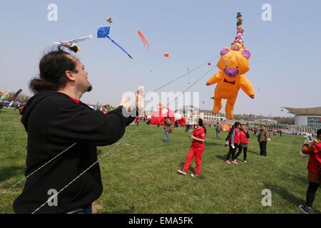 Weifang, China's Shandong Province. 18th Apr, 2015. Participants fly kites during a kite fair held in Weifang, east China's Shandong Province, April 18, 2015. Kites-flying fans from China and abroad took part in the fair on Saturday. Credit:  Zhang Chi/Xinhua/Alamy Live News Stock Photo