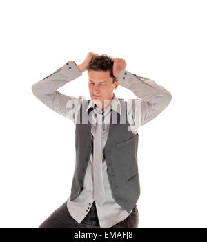 A young man in a gray shirt and vest sitting and scratching his head,  wondering what is going on, isolated for white background Stock Photo