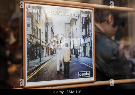 London, UK. 18 April 2015. The Oasis album '(What's The Story) Morning Glory?', which depicted Berwick Street on its cover, hangs in a window as lovers of vinyl music gather to browse and purchase in Soho's famous Berwick Street on Record Store Day, 18 April 2015.  The event is a celebration of enjoying music in a physical format, and reflects the recent resurgence in sales of vinyl music. Credit:  Stephen Chung / Alamy Live News Stock Photo
