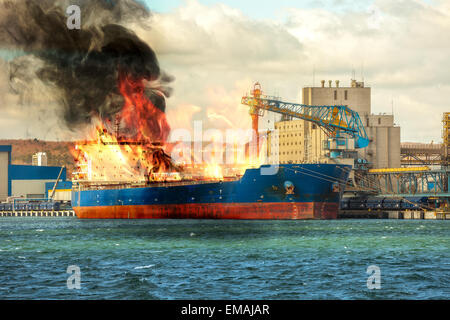 Burning cargo ship in the port. Stock Photo