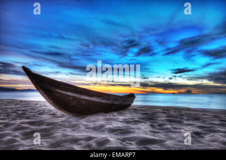 Old fisherman boat at sunrise time on the beach Stock Photo