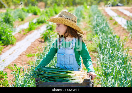 Litte kid farmer girl in onion harvest at orchard Stock Photo