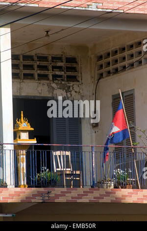 A Buddhist spirit house & a Cambodian flag are displayed on the balcony of a typical upper middle home in Kampong Cham, Cambodia Stock Photo