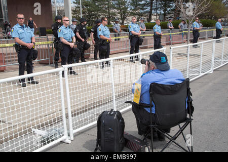 Toledo, Ohio - A photographer sitting in a chair photographs police who were lined up to protect a neo-Nazi rally. Stock Photo