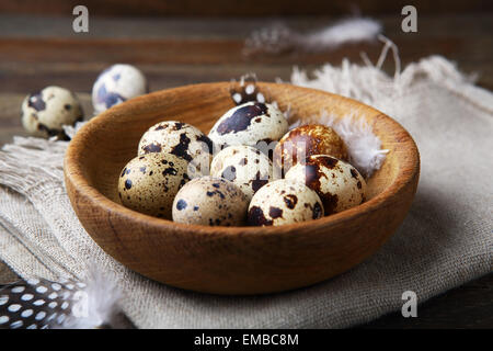 Quails eggs in bowl on rustic table Stock Photo