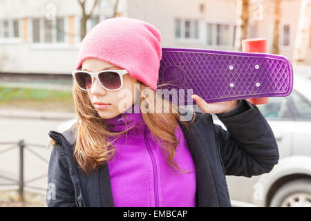 Blond beautiful teenage girl in sunglasses with skateboard, outdoor portrait Stock Photo