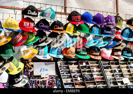 Rows of baseball caps and sunglasses for sale on a market stall in Whitby, North Yorkshire, England. Stock Photo