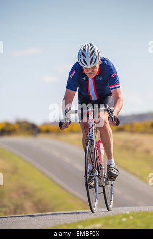 An elderly male cyclist competes in the New Forest Wiggle Sportive event on a sunny Sunday in Spring Stock Photo