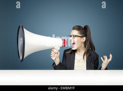 Young pretty businesswoman yelling over megaphone Stock Photo
