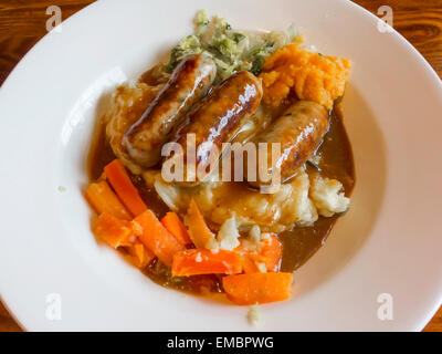 Pub Sunday lunch main course Pork and Leek Sausages with mashed potatoes swede carrots cabbage and rich onion gravy Stock Photo