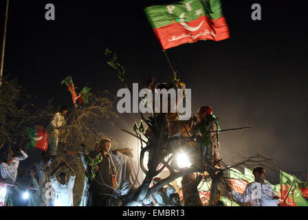 Karachi, Pakistan. 19th Apr, 2015. Supporters of Pakistan Tehrik-e-Insaf (PTI) or Justice Movement wave party flags during a by-election campaign rally in southern Pakistani port city of Karachi, April 19, 2015. Pakistan's ruling party agreed last month to form a judicial commission to investigate alleged rigging in the 2013 general elections after months of negotiations with Imran Khan, who leads PTI. Credit:  Masroor/Xinhua/Alamy Live News Stock Photo