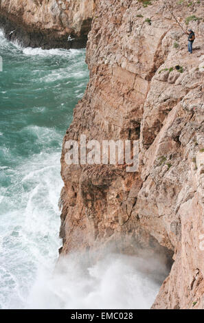 Severe dramatic seascape with fisherman in Cape Saint Vicent cliffs, Portugal Stock Photo