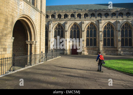 Child scooter alone, on his way to school a small child rides a scooter through the cathedral close in Bury St. Edmunds, UK. Stock Photo