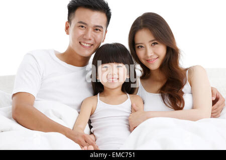 The happiness of a family of three in the bed of the bedroom Stock Photo