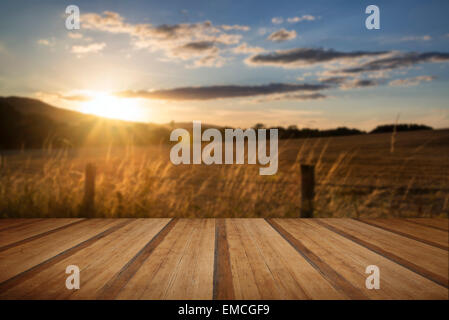 Beautiful Summer image of sun shining and backlighting countryside landscape with wooden planks floor Stock Photo