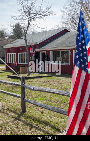 Flags fly in front of a roadside antique store in Vermont on a sunny spring day. Stock Photo