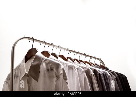 Several shirts on a hanger from white to black color range Stock Photo