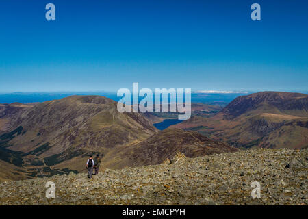 Two walkers descending from the top of Great Gable heading towards Ennerdale and Buttermere in spring, Lake District, UK with copy space Stock Photo