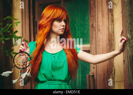 https://l450v.alamy.com/450v/emd51e/creative-portrait-of-redhead-young-woman-in-green-dress-with-dream-catcher-in-her-hands-long-beautiful-red-hairselective-focus-emd51e.jpg