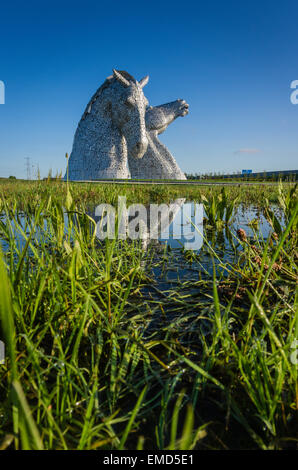 Dramatic daytime shot of the Kelpies horse head statues sculpture in Falkirk, Scotland, UK on a sunny day against a blue sky Stock Photo