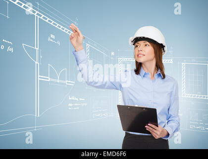 smiling businesswoman in helmet with clipboard Stock Photo