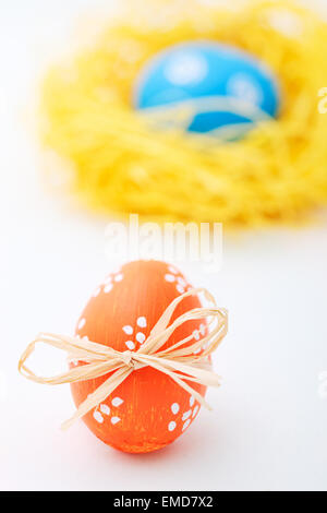 Colorful easter eggs in the nest on grass field with trees and blue sky ...
