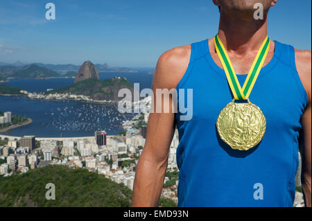 First place athlete wearing gold medal standing outdoors at Rio de Janeiro Skyline Stock Photo
